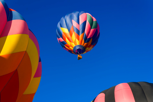 A colorful hot air balloon framed by two other balloons.