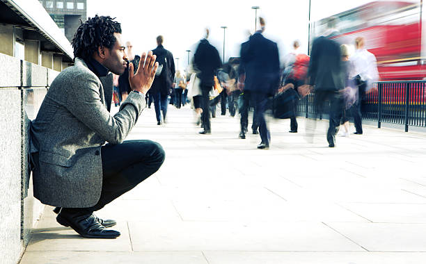 kontemplacja z kontrastującym solitary znak przeciwko hurried świecie - begging pleading praying business zdjęcia i obrazy z banku zdjęć