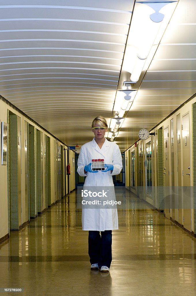 Wissenschaftler hält Reagenzglasständer zu Fuß in Gang - Lizenzfrei Ganzkörperansicht Stock-Foto