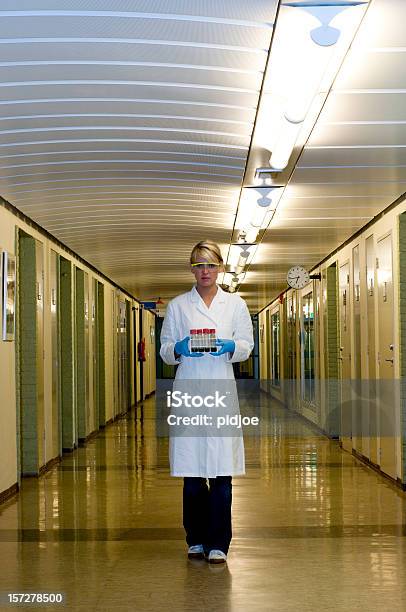 Cientista Segurando Prateleira De Tubos De Ensaio A Caminhar Na Hallway - Fotografias de stock e mais imagens de De Corpo Inteiro