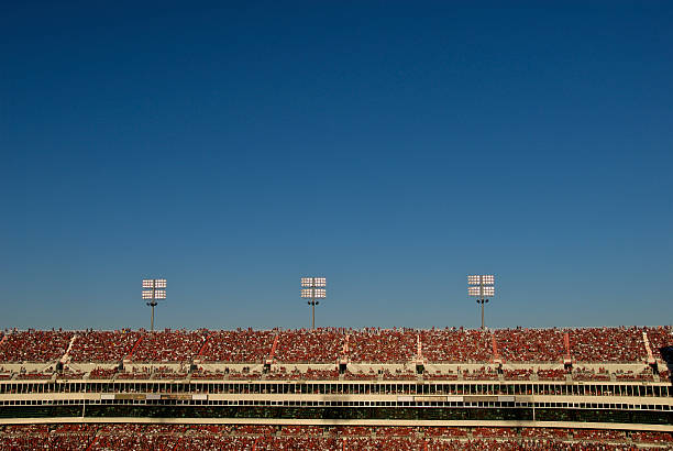 Stadium Crowd Under Blue Sky Thousands of fans gathered for a sporting event in late afternoon sun. Need photos representing the people, places and natural beauty of Arkansas? Please see these...  school bleachers stock pictures, royalty-free photos & images