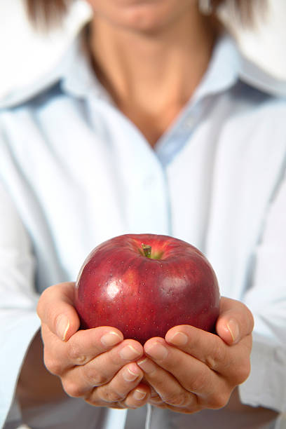 istock Woman is holding red apple in hands, focus on apple 157278856