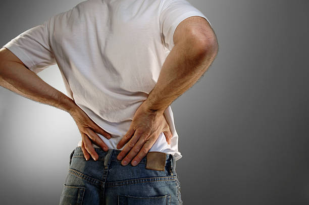 lässig gekleidete mann mit rückenschmerzen - back rear view pain backache stock-fotos und bilder