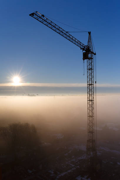 Construction crane in the fog at dawn
