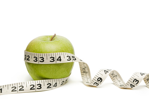 Green Apple isolated on white with measuring tape. Great diet concept.