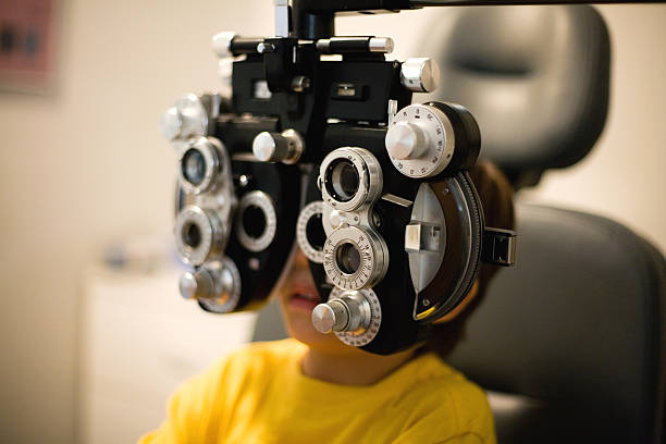 Child Eye Exam Preschool boy having an eye exam. Natural dim light. mm1 stock pictures, royalty-free photos & images