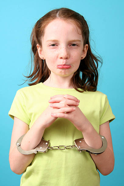 Juvenile Delinquent...sort of Poor &quot;innocent&quot; eight year old in handcuffs, must have forgotten to clean her room child arrest stock pictures, royalty-free photos & images