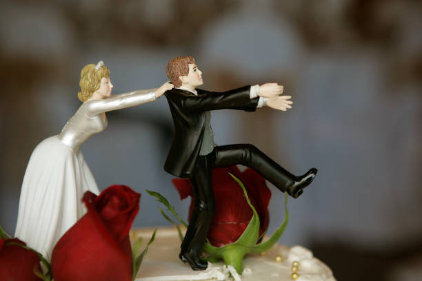 Wedding Cake Top Funny couple figurine on the wedding cake. white wedding cake red roses stock pictures, royalty-free photos & images