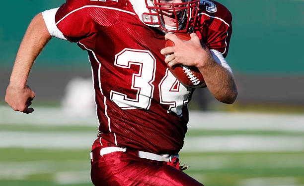 running back - football human hand holding american football - fotografias e filmes do acervo