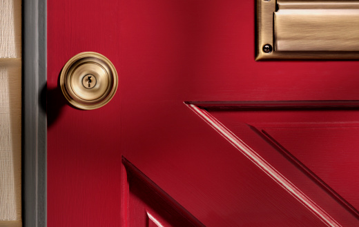 Close up picture of a doorknob on a red door