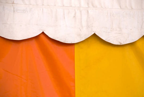 This image showcases a reconstructed historical encampment featuring a spacious white canvas tent typical of medieval times, alongside authentic leather accessories resting on rustic wooden benches