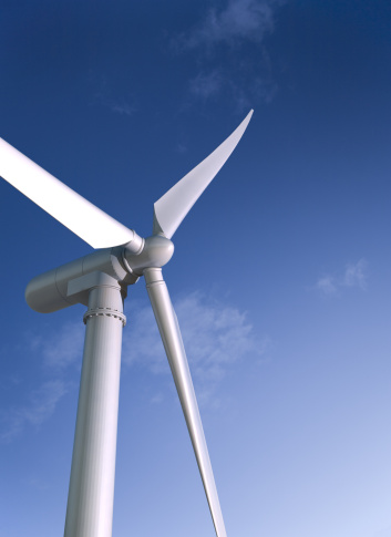 A wind turbine against a blue sky. 3D render with HDRI lighting and raytraced textures.