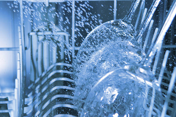 interior of operating dishwasher with water splashing on wine glasses - diskmaskin bildbanksfoton och bilder