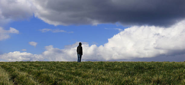 istock Male Standing Alone in Dark Field 157280942