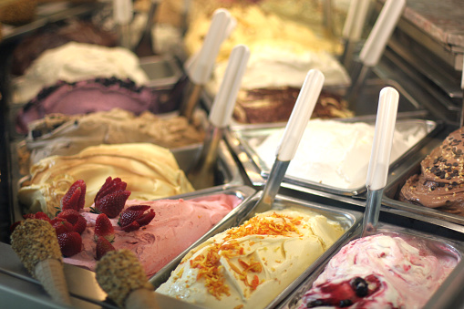 Lots of flavours of ice cream as seen through a store window