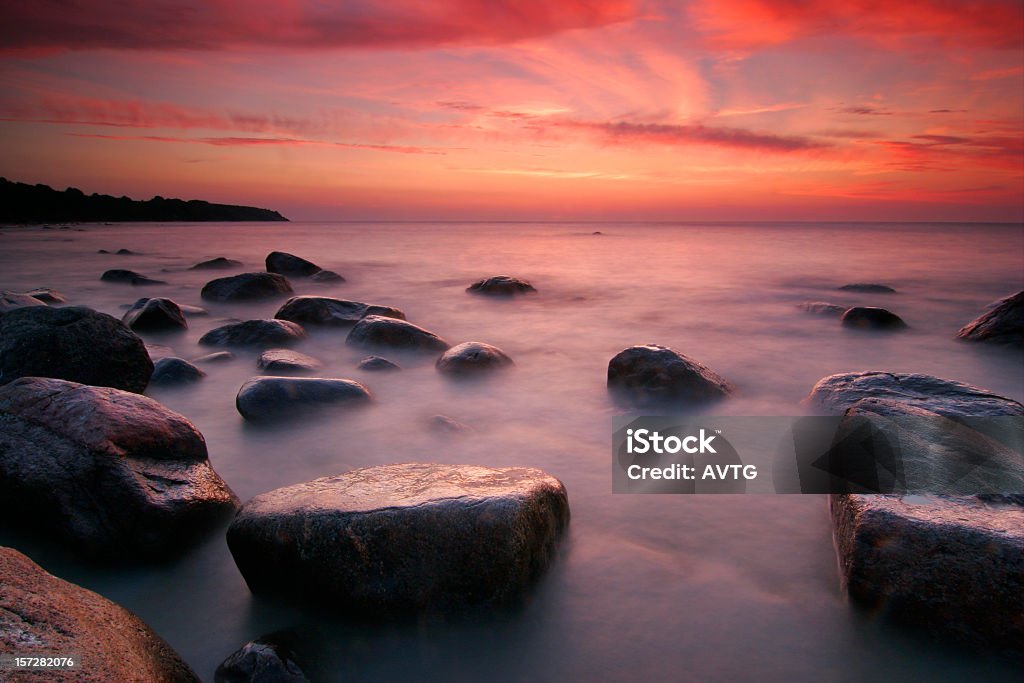 Coastal Sunset moody nightfall an a rocky shore  Backgrounds Stock Photo