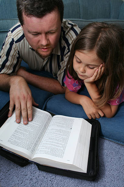 istock Father and Daughter Reading The Bible 157282189