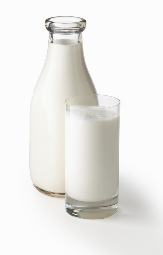 Quart bottle of milk with glass of milk shot on clean white background with soft drop shadow.  Large file includes path.