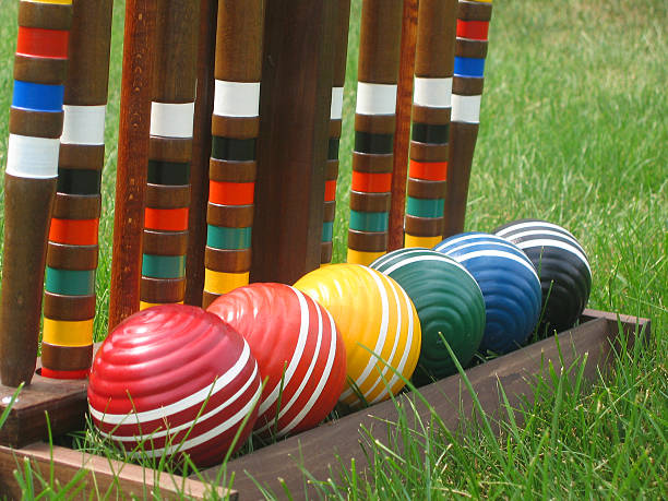 Close-up of croquet balls lined up in their wooden holder. Sitting in the grass. Balls lined up in spectrum order.See also:http://www.istockphoto.com/file_thumbview_approve.php?size=1&id=802106