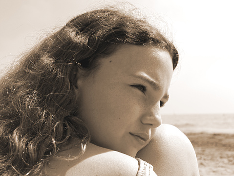 My daughter enjoying 1 st time at beach. Sepia.