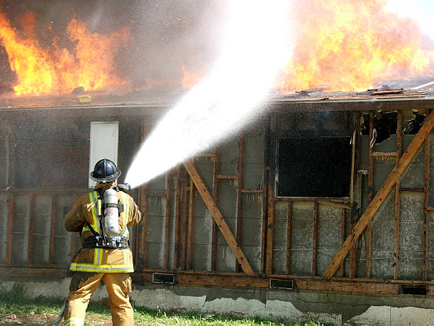 istock A firefighter bravely extinguishing flames on building 157282390