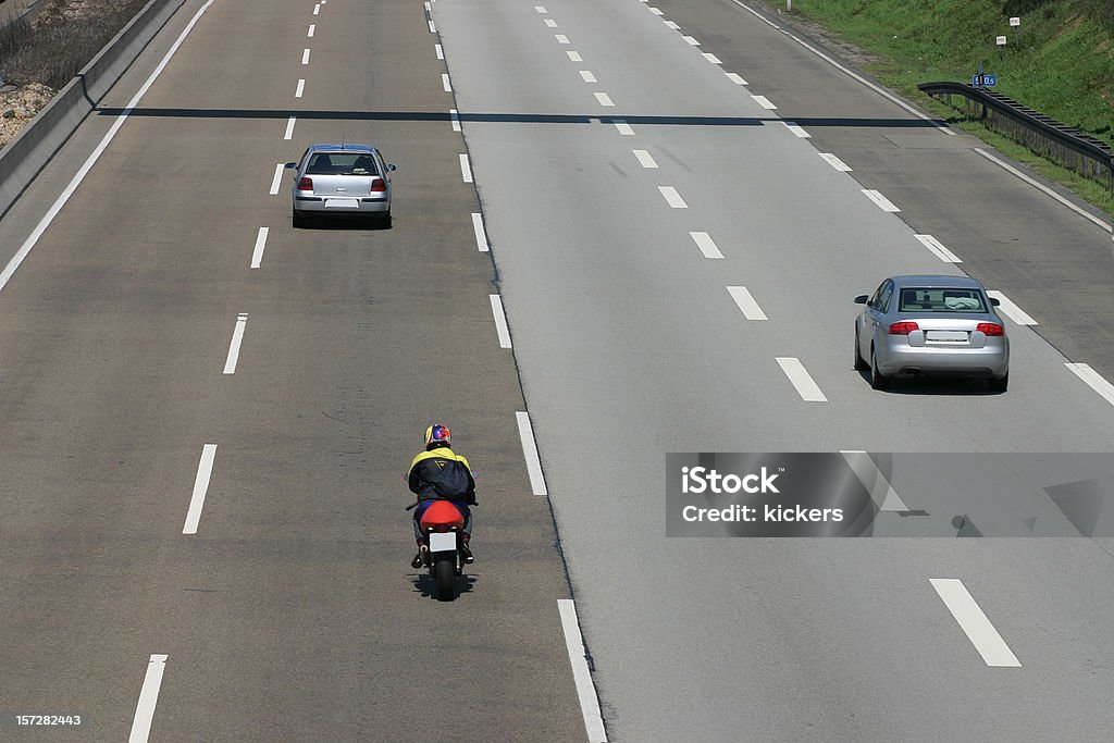 Cars and motorcycle on a quiet four-lane highway Some cars and motorbikes on the highway from the back. Motorcycle Stock Photo