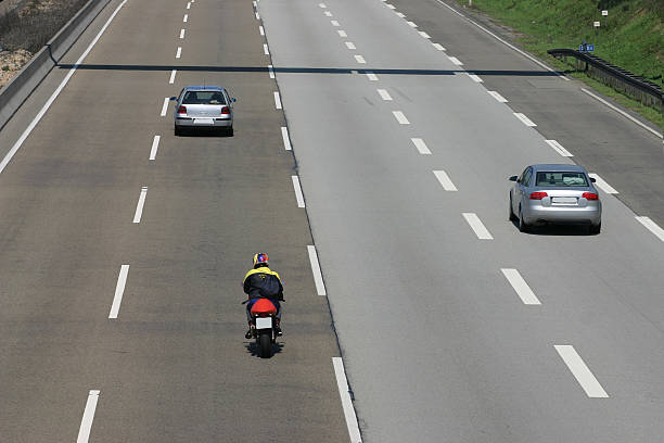 Cars and motorcycle on a quiet four-lane highway stock photo