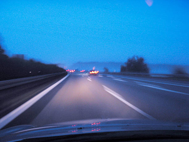 A blurred view from inside a vehicle navigating a snowstorm, showing challenging driving conditions.