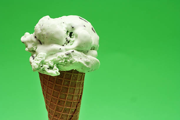 Mint Ice Cream Cone on Green Background stock photo