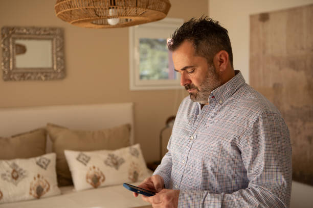 istock Adult man using mobile in his bedroom 1572829160