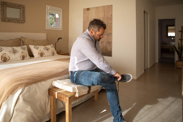 istock Adult man putting on socks and shoes 1572829692
