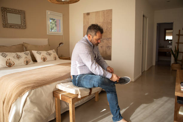 istock Adult man putting on socks and shoes 1572829696