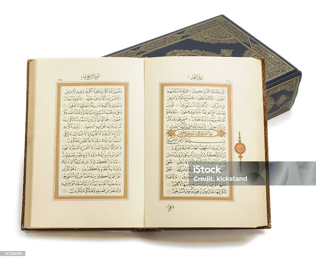 Holy Korans with clipping path Two copies of the Muslim holy book, the Koran or Qur'an. The open copy is printed in classical written Arabic and rests on a closed copy with calligraphic cover. Books printed in the early 20th Century. Clipping path included. Arabic Script Stock Photo