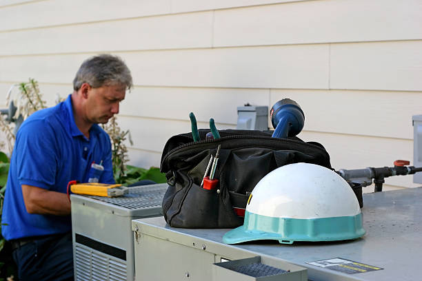 Air conditioner repairman working on an outdoor unit stock photo