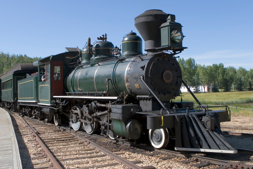 A steam locomotive beside a railway station platform.
