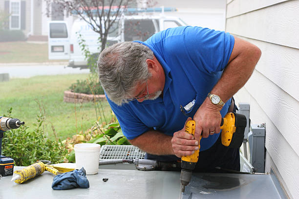 AC Repair 9 showing a Man Drilling a Table with a Drill stock photo