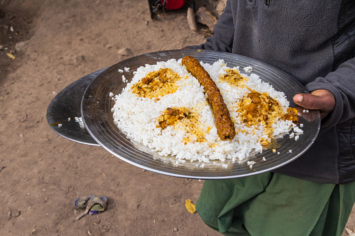 Kangan, Jammu and Kashmir, India. Food being served at a village wedding in Jammu and Kashmir.