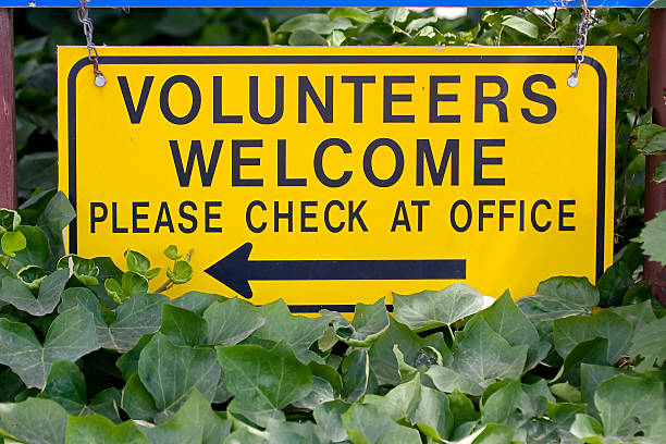 Volunteers Welcome Sign, Please Check at Office. stock photo