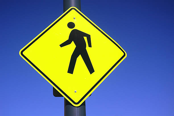 A sign integrated into the concrete sidewalk of a city park instructs visitors to just \