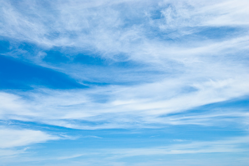 Cirrus clouds appear in a blue sky over Rogers Lake near Flagstaff, Arizona, USA.