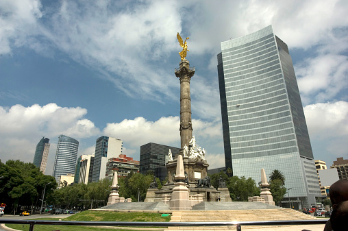The Angel of Independence and the roundabout Paseo de la Reforma Mexico City.  The Angel of Independence, most commonly known by the shortened name El Ángel and officially known as Monumento a la Independencia, is a victory column on a roundabout over Paseo de la Reforma in downtown Mexico City. El Ángel was built in 1910 to commemorate the centennial of the beginning of Mexico's War of Independence. In later years it was made into a mausoleum for the most important heroes of that war. It is one of the most recognizable landmarks in Mexico City, and it has become a focal point for both celebration or protest. Paseo de la Reforma is a wide avenue that runs diagonally across the heart of Mexico City. It was designed by Ferdinand von Rosenzweig in the 1860s and modeled after the great boulevards of Europe. 