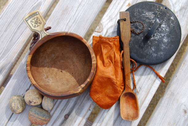 Sami handmade objects; kuksa (juniper), leather purse, wooden spoon, blackned campfire kettle lid.