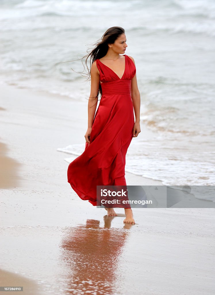 Rosso Donna sulla spiaggia - Foto stock royalty-free di Vento