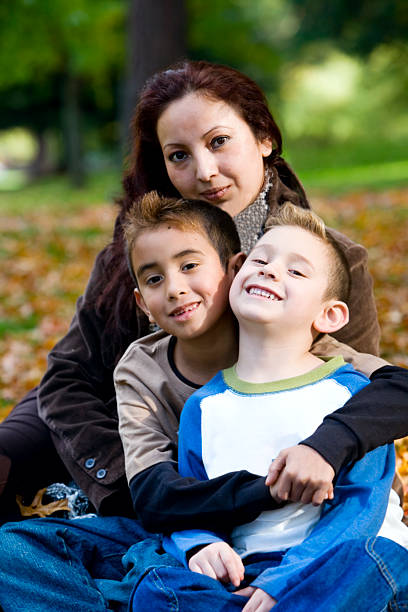 istock Beautiful Loving Hispanic Mother with Sons on Fall Day 157287581
