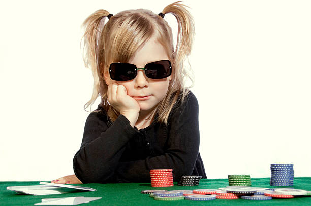 Poker Face A young girl pretending to play poker. child gambling chip gambling poker stock pictures, royalty-free photos & images