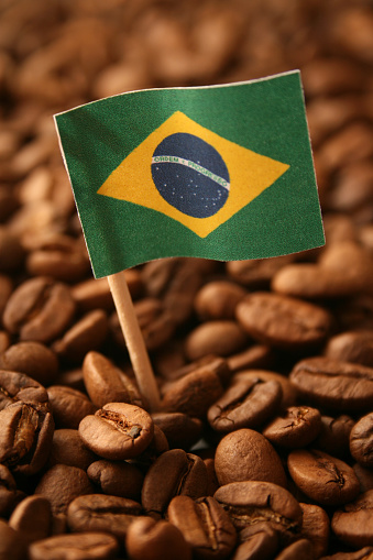 Brazilian flag over coffee grains for production concept
