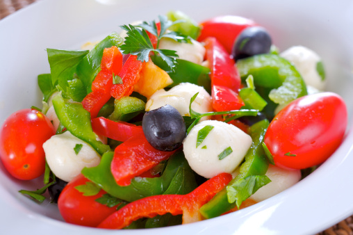 Fresh salad with mozarella, cherry tomatoes, olives and green and red pepper