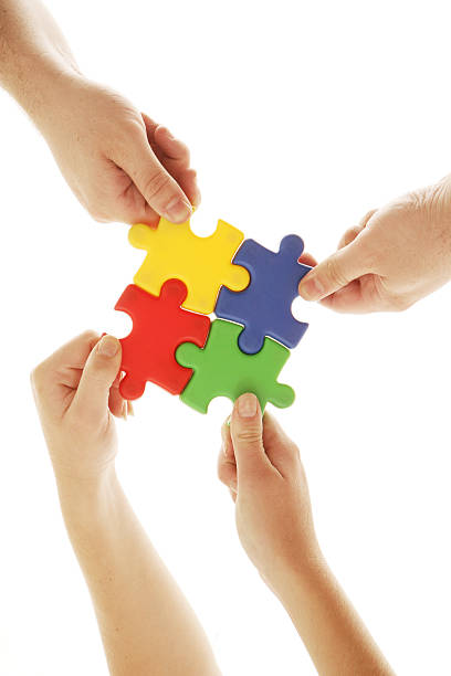 istock Colleagues putting puzzle pieces together with team work 157287831