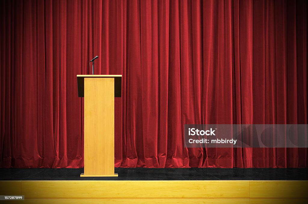 Business conference with rostrum Rostrum with microphone and red curtain behind. Waiting for speech. Just add text or person on photo! Be creative. Taken on event Minilypse, Kamnik, 2007. Lectern Stock Photo