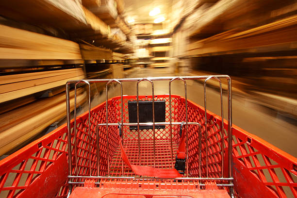 View over filled shopping cart racing down a supermarket aisle towards an out-of-focus woman shopper with extreme motion blur transforming into rainbow streaks along the shelves. NOTE: The product labels in the cart are dummies made by the photographer.